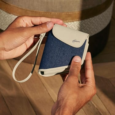 Χέρι που κρατάει μια θήκη μεταφοράς Ploom Duo Denim Leather Fusion αξεσουάρ